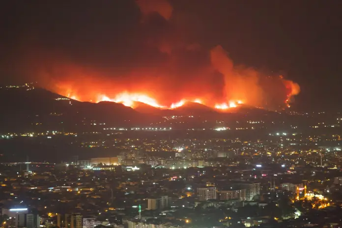 aerial night view of intense wildfires near city
